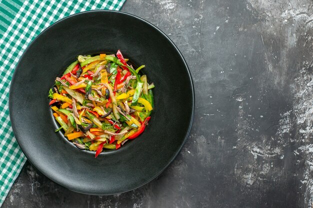 Vue de dessus de la salade de légumes savoureuse sur une surface sombre