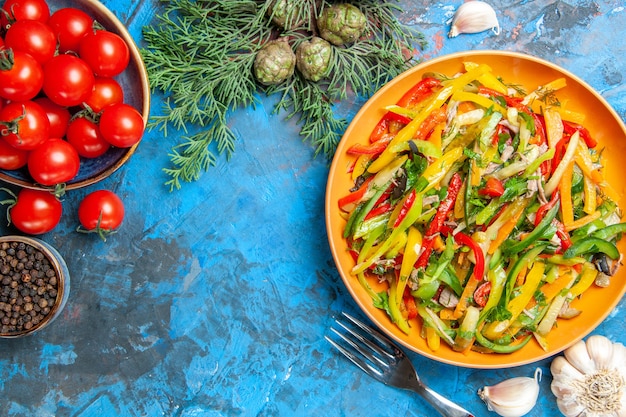 Vue de dessus de la salade de légumes savoureuse sur une surface sombre