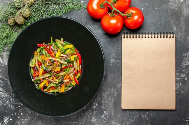 Vue de dessus de la salade de légumes savoureuse sur une surface sombre