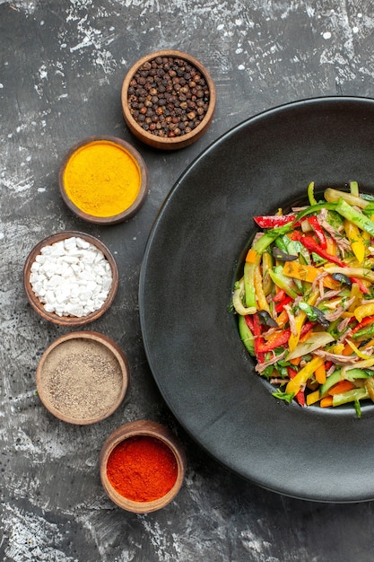 Vue de dessus de la salade de légumes savoureuse sur une surface sombre