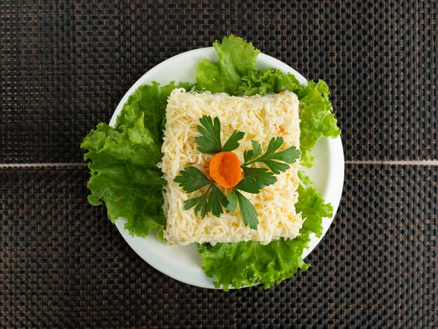 Vue de dessus de la salade de mimosa garnie de persil et de fleur de carotte