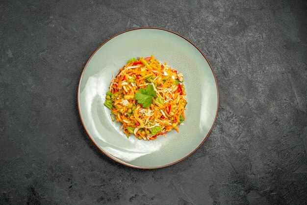 Vue de dessus de la salade de poulet aux légumes à l'intérieur de la plaque sur la nourriture diététique de la salade de santé sombre