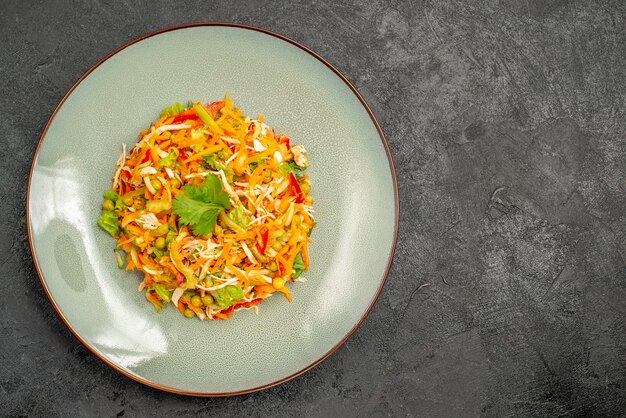 Vue de dessus de la salade de poulet aux légumes à l'intérieur de la plaque sur la nourriture diététique de la salade de santé sombre