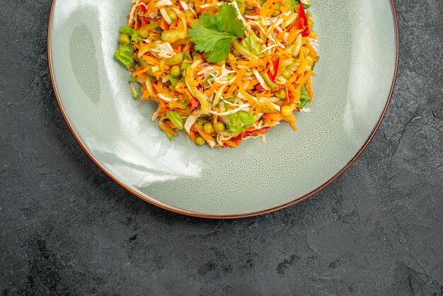 Vue de dessus de la salade de poulet aux légumes à l'intérieur de la plaque sur un sol sombre, des aliments diététiques de salade de santé