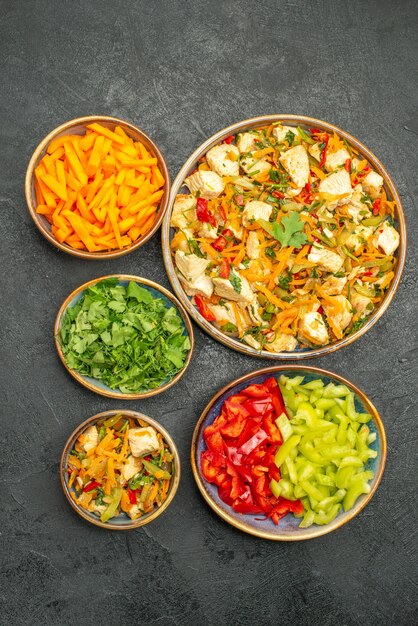 Vue de dessus salade de poulet aux légumes sur la salade de santé de régime de plancher gris foncé