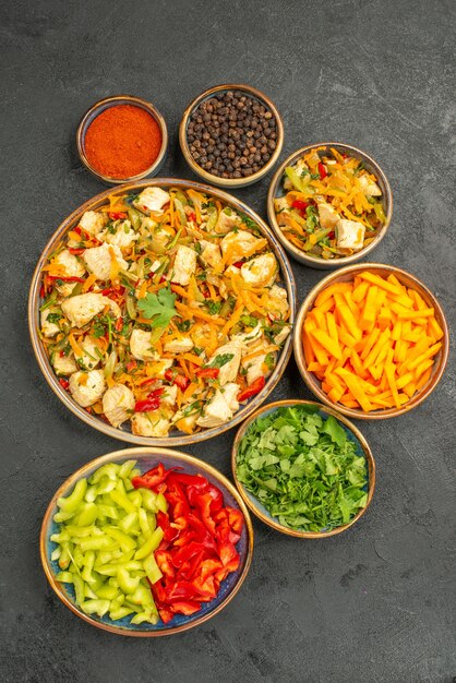 Vue de dessus salade de poulet avec des légumes et des verts sur la santé de la salade de régime de bureau sombre