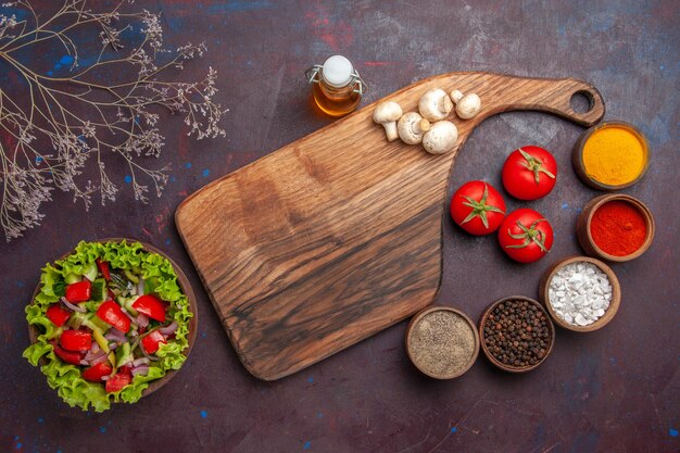 Vue de dessus salade et salade d'épices avec tomates oignons poivrons verts et huile de laitue différentes épices et champignons