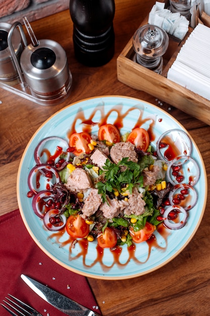 Vue de dessus de la salade de thon à l'oignon rouge et aux tomates sur une plaque