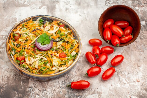 Vue de dessus de la salade végétalienne et des tomates fraîches tombées d'un petit pot