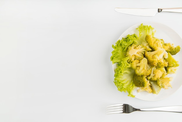 Vue de dessus salade verte avec couverts et copie-espace