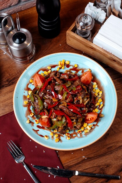 Vue de dessus de la salade de viande avec du poivron tomate et du maïs sur une plaque