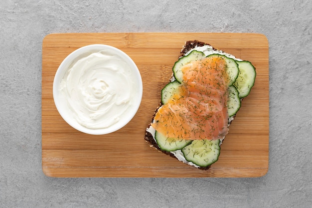 Photo gratuite vue de dessus sandwich avec concombres et saumon sur une planche à découper