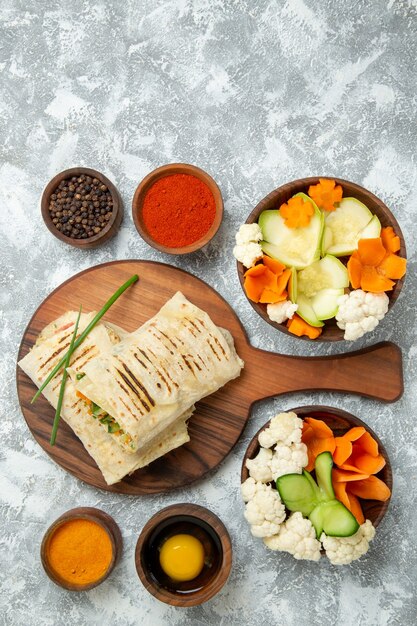 Vue de dessus sandwich en tranches avec des légumes et des assaisonnements sur fond blanc pain repas sandwich burger food