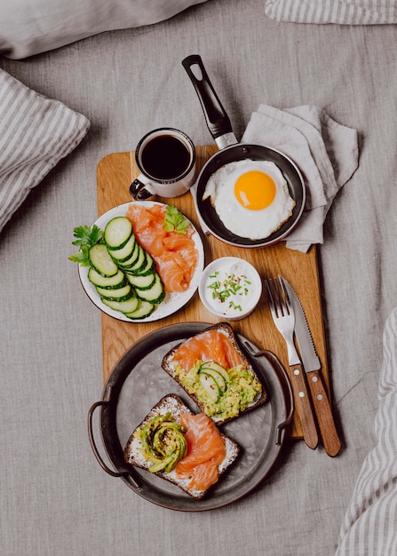 Vue de dessus des sandwichs au petit déjeuner sur le lit avec oeuf au plat et pain grillé