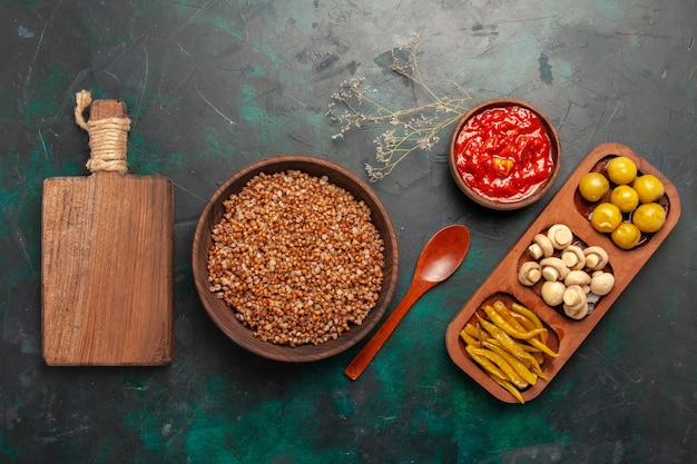 Vue de dessus sarrasin cuit avec sauce tomate sur la surface vert foncé