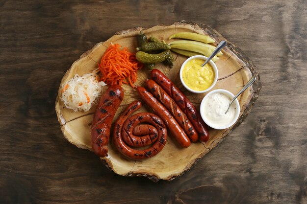 Vue de dessus des saucisses grillées avec accompagnements et sauces