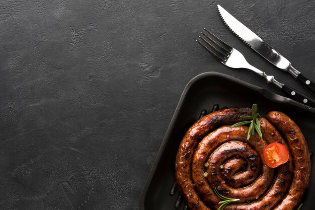 Vue de dessus des saucisses grillées avec des couverts sur la table