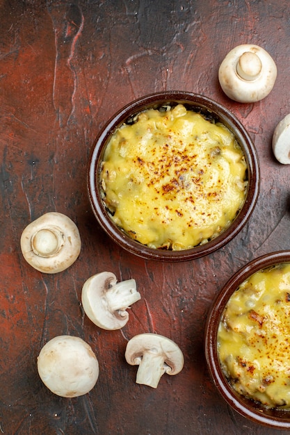 Vue de dessus savoureuse julienne dans des bols de champignons sur marron