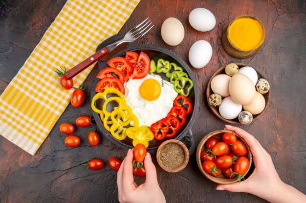 Vue de dessus savoureuse omelette avec des poivrons tranchés et des assaisonnements sur la table sombre