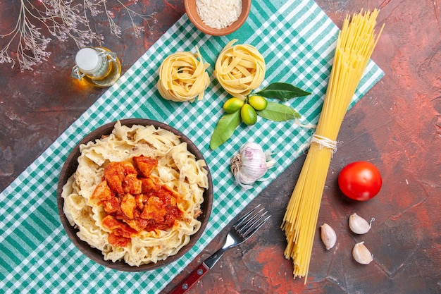 Vue de dessus savoureuse pâte cuite avec du poulet et de la sauce sur un plat de pâtes de couleur foncée