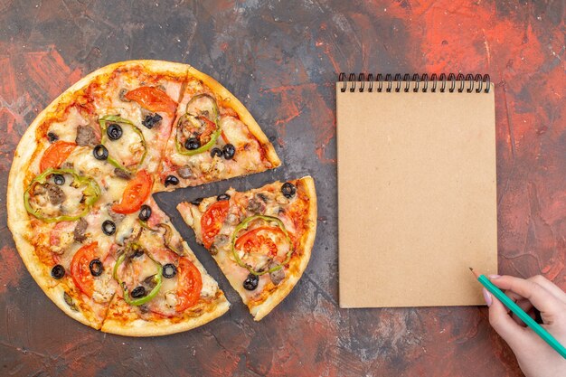 Vue de dessus savoureuse pizza au fromage tranchée et servie sur une surface brun foncé