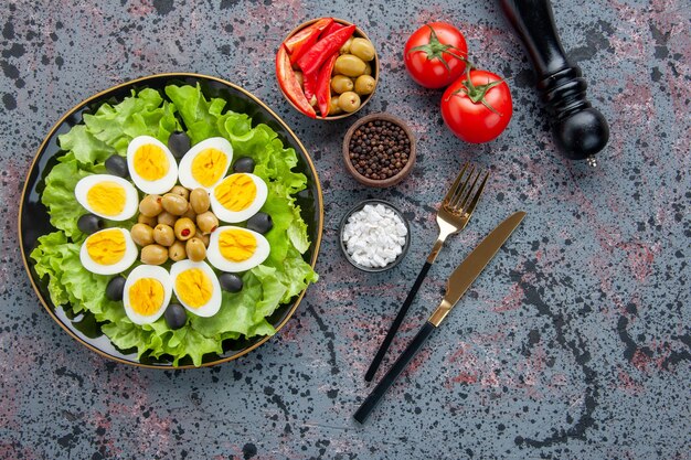 Vue de dessus savoureuse salade aux œufs avec assaisonnements et olives sur fond clair