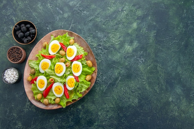 Vue De Dessus Savoureuse Salade Aux œufs Avec Des Olives Salade Verte Et Assaisonnements Sur Fond Bleu Foncé