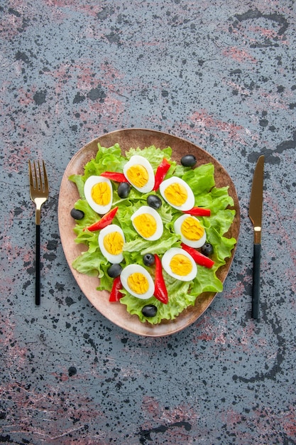 Vue de dessus savoureuse salade aux œufs avec salade verte et olives sur fond clair