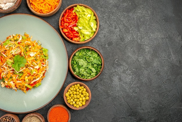 Vue de dessus savoureuse salade avec des ingrédients sur un régime alimentaire sain gris foncé