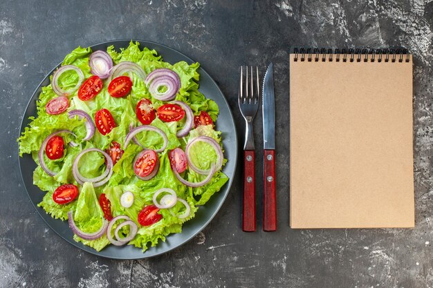 Vue de dessus savoureuse salade de légumes aux oignons salade verte et tomates sur fond gris photo couleur alimentaire salade santé régime repas mûr