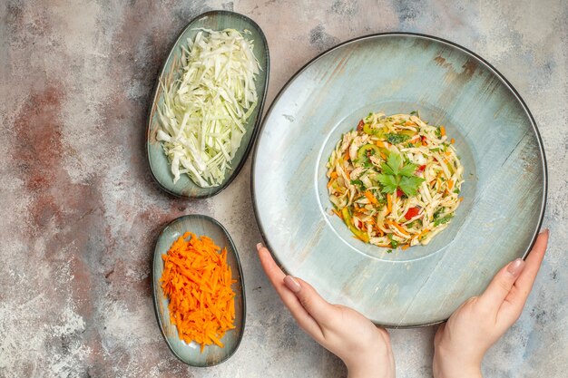 Vue de dessus savoureuse salade de légumes avec carottes tranchées et chou sur fond clair