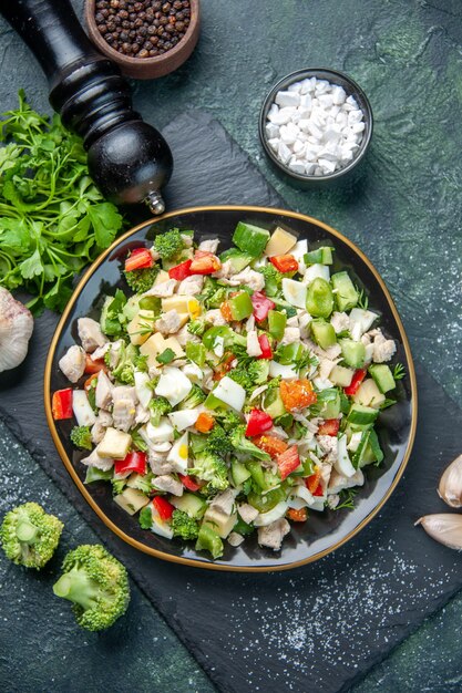Vue de dessus savoureuse salade de légumes à l'intérieur de la plaque sur fond bleu foncé couleur cuisine déjeuner restaurant repas régime santé