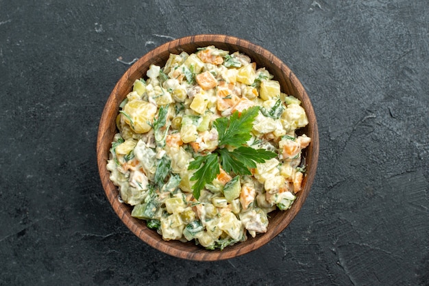 Vue de dessus savoureuse salade mayyonaise à l'intérieur de la plaque brune sur fond noir