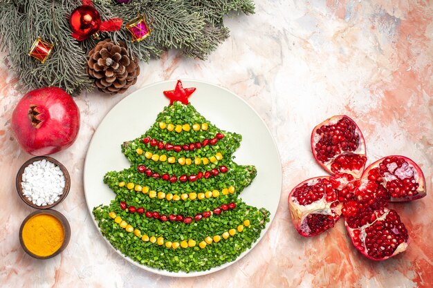 Vue de dessus savoureuse salade verte en forme d'arbre de nouvel an avec des assaisonnements sur un bureau léger repas de vacances santé photo couleur de Noël