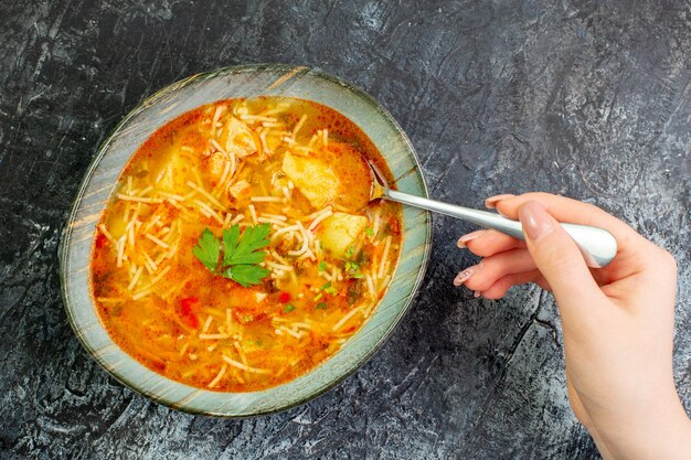 Vue de dessus savoureuse soupe aux vermicelles à l'intérieur de l'assiette sur la table gris clair