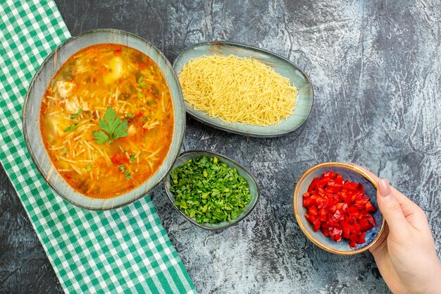 Vue de dessus savoureuse soupe de vermicelles avec des verts et des vermicelles crus sur une table gris clair