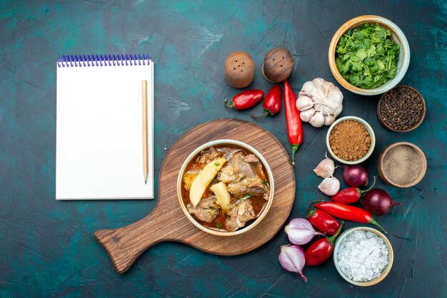 Vue de dessus savoureuse soupe à la viande avec des légumes cuits avec des assaisonnements et des légumes frais sur la viande de soupe repas repas sombre