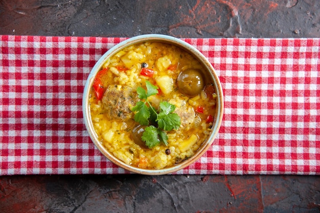 Vue de dessus savoureuse soupe de viande avec pommes de terre et riz à l'intérieur d'une petite assiette sur une surface sombre repas nourriture salade restaurant dîner cuisine plat horizontal