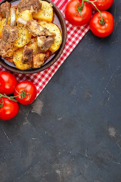 Vue de dessus savoureuse viande bouillie avec pommes de terre cuites et tomates sur fond sombre plat sauce cuisson cuisine cuisine dîner de viande chaude