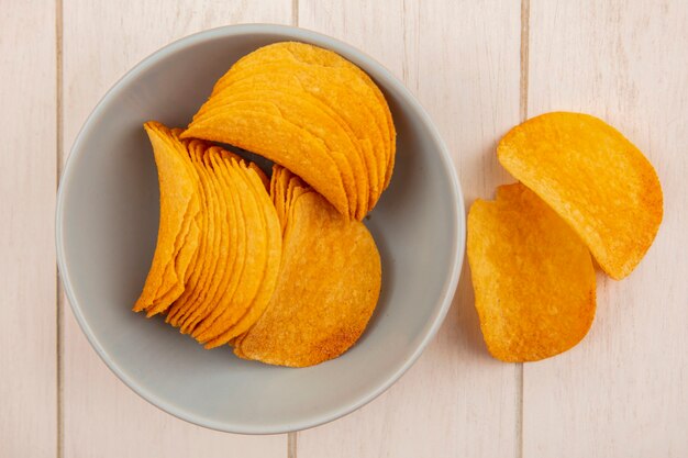 Vue de dessus de savoureuses chips croustillantes sur un bol sur une table en bois beige