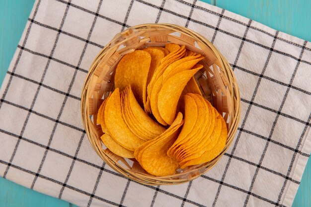 Vue de dessus de savoureuses chips croustillantes sur un seau sur un chiffon vérifié