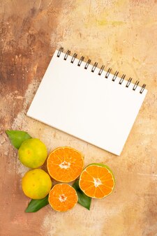 Vue de dessus de savoureuses mandarines fraîches avec bloc-notes