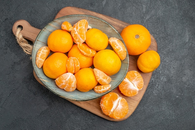 Vue de dessus de savoureuses mandarines juteuses à l'intérieur de la plaque sur fond gris