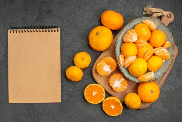 Vue de dessus de savoureuses mandarines juteuses à l'intérieur de la plaque sur fond gris