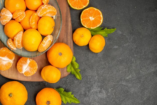 Vue de dessus de savoureuses mandarines juteuses à l'intérieur de la plaque sur fond gris