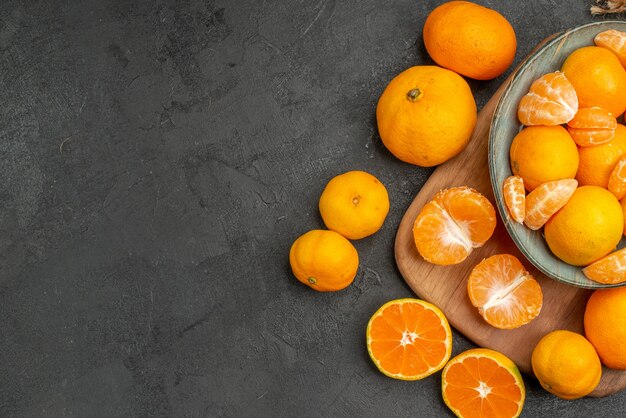 Vue de dessus de savoureuses mandarines juteuses à l'intérieur de la plaque sur fond gris