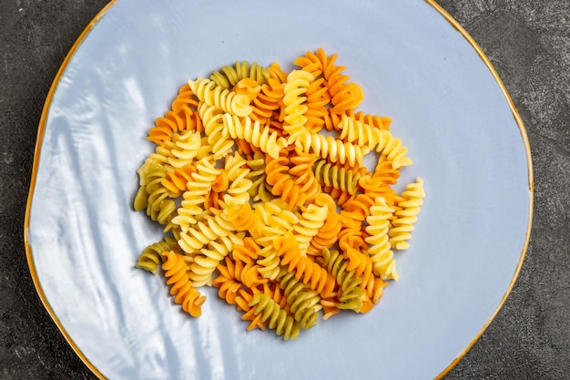 Vue de dessus de savoureuses pâtes italiennes pâtes en spirale cuites inhabituelles sur le noir