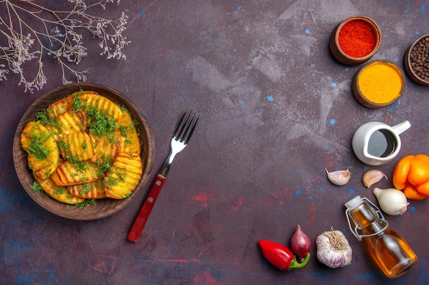 Vue de dessus de savoureuses pommes de terre cuites avec des légumes verts sur la surface sombre plat de repas du dîner cuisson des pommes de terre