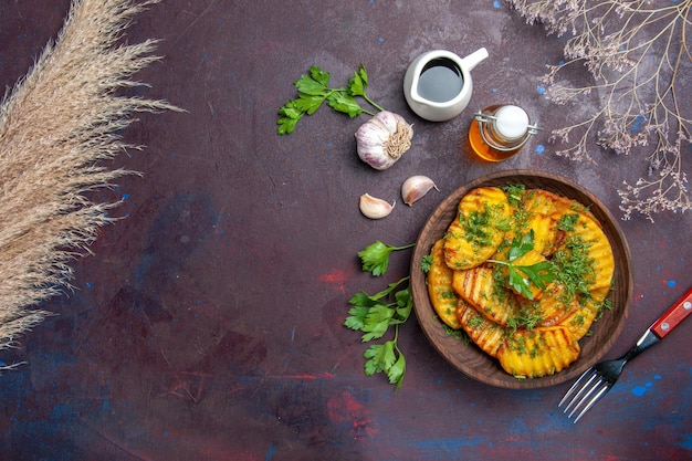 Vue de dessus savoureuses pommes de terre cuites plat délicieux avec des légumes verts sur la surface sombre repas de cuisson plat de pommes de terre dîner