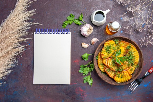 Vue de dessus savoureuses pommes de terre cuites plat délicieux avec des légumes verts sur une surface sombre repas de cuisson pommes de terre plat de dîner